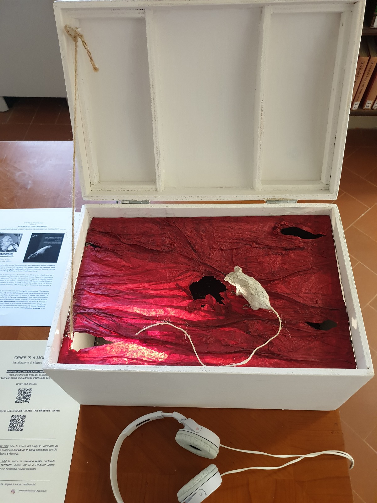 Image showing the entire chest Grief Is a Mouse, with a papier-mâché mouse sculpture on a lit red base.