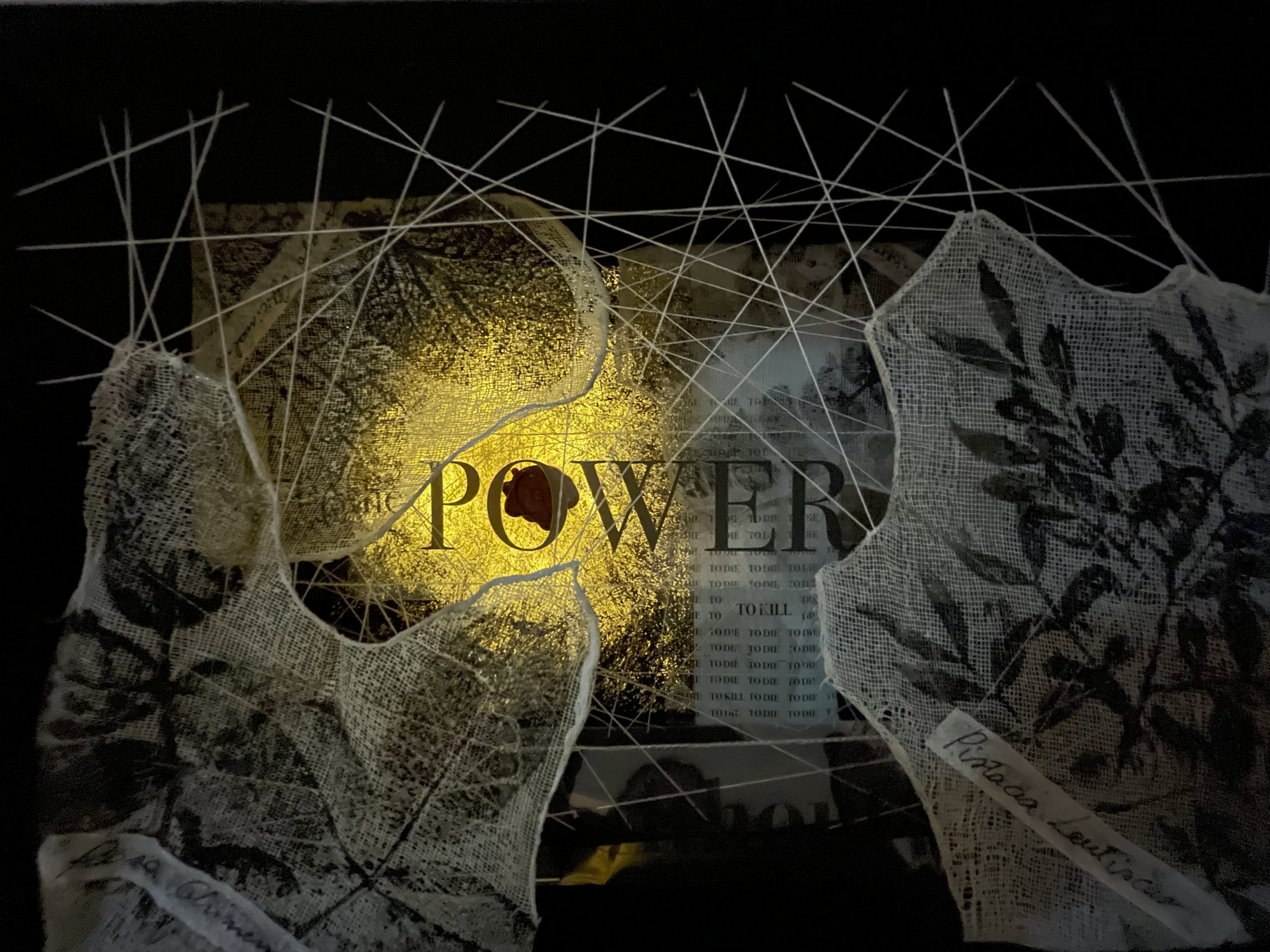 Scrigno, con all'interno un intreccio di stoffe, fili, ricorrenze della parola Power e stampe di fiori.